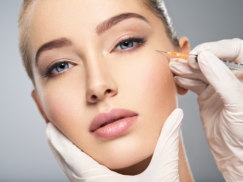 Woman receiving facial filler injection