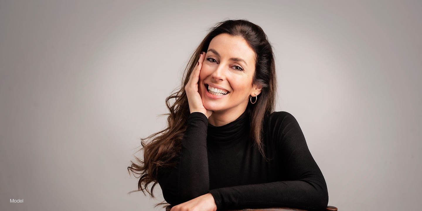 Happy woman in a black long sleeve shirt sitting on a chair